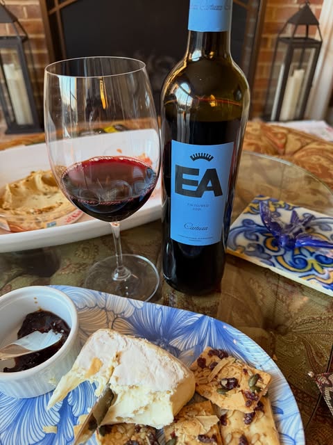 A glass of Alentejo red poured beside bread and cheese on a tiled table